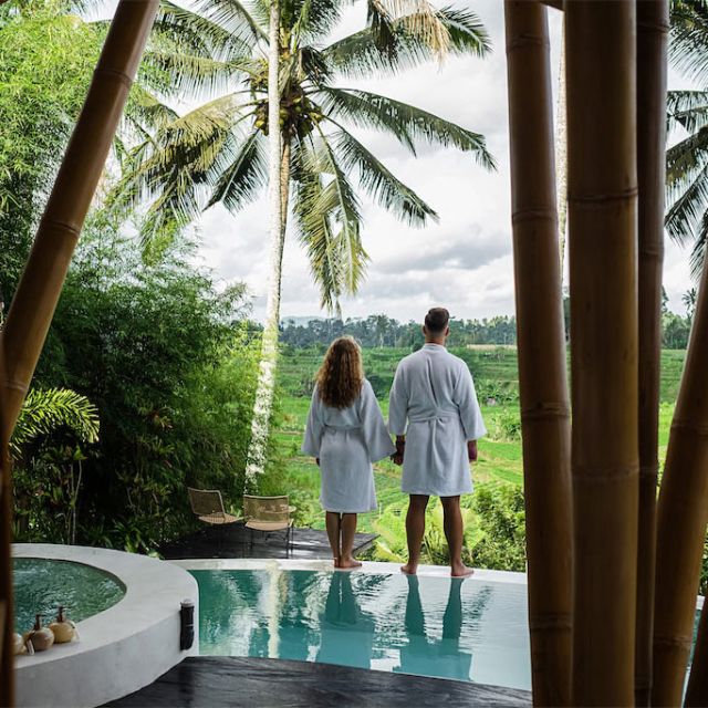 Paar an Pool in Luxussuite, Palmen